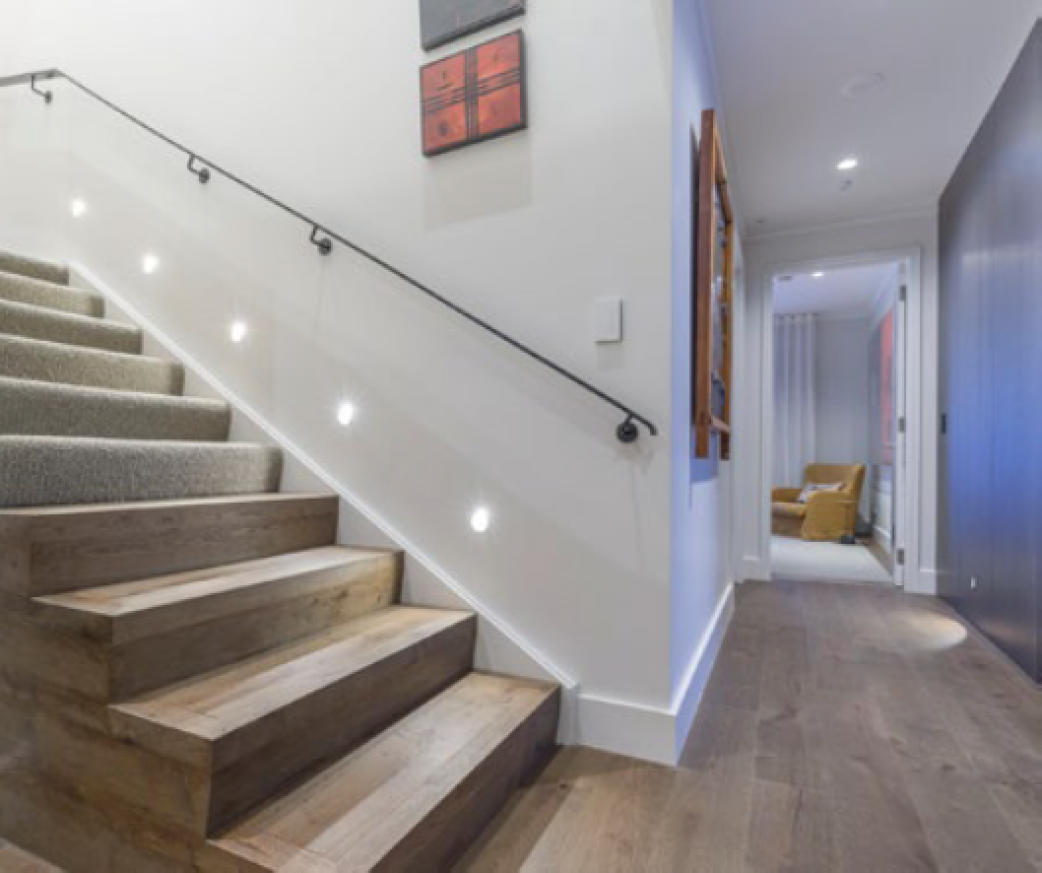 Una escalera luminosa con parquet idéntico al suelo HARO conduce de la planta baja a las habitaciones superiores.